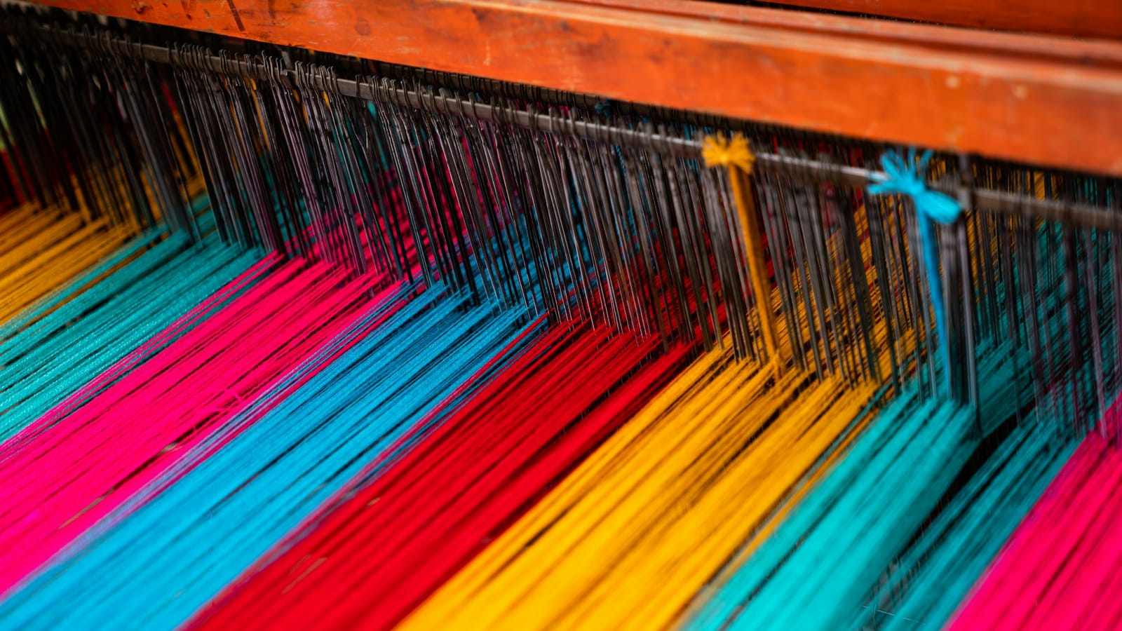 Brightly coloured warp yarns on a loom