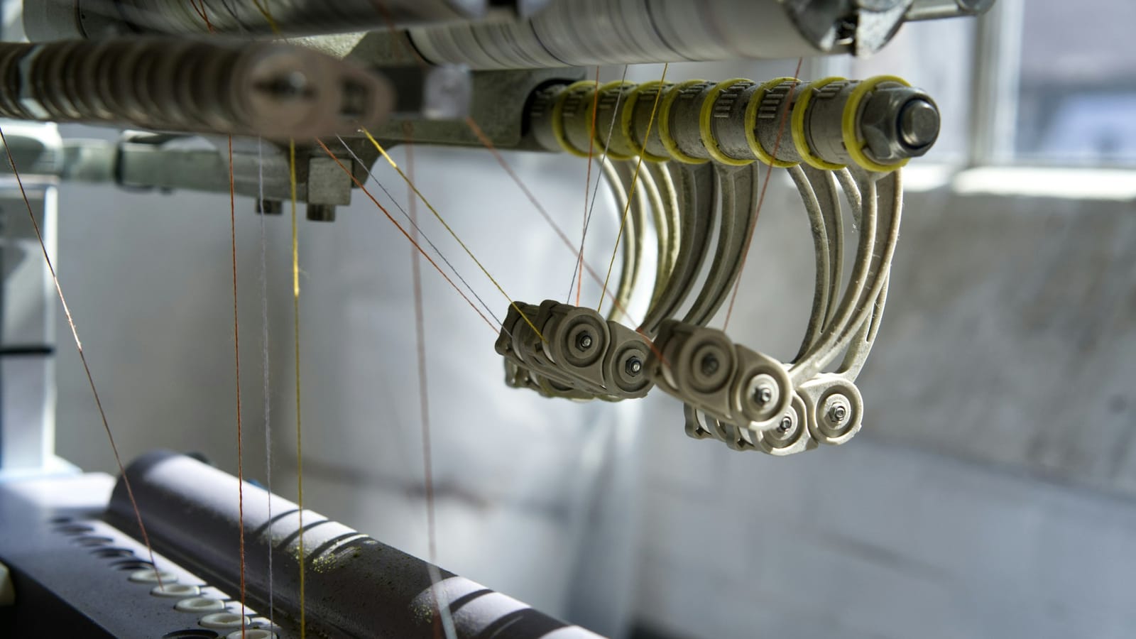 Close-up of yarn guides on a textile machine