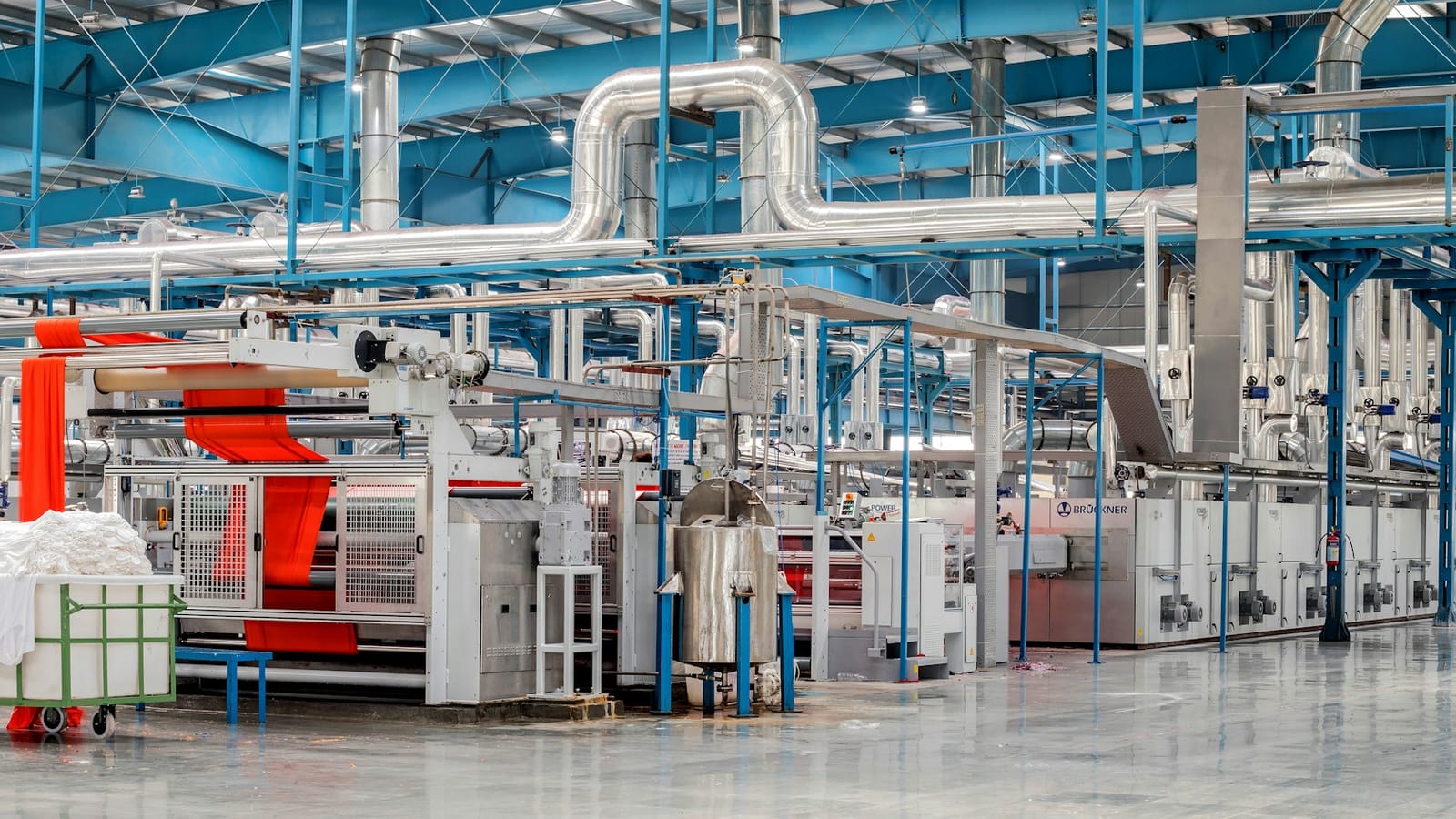 Modern textile finishing plant with machinery, pipework and fabric on the range