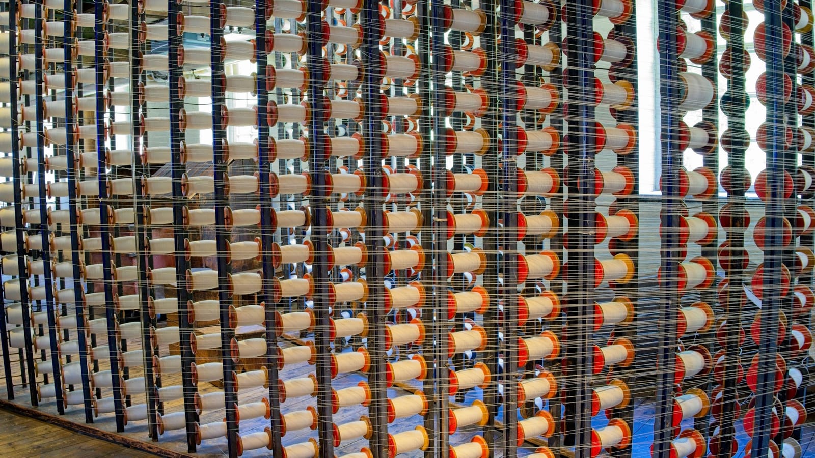 Rows of thread spools on a creel in a textile mill