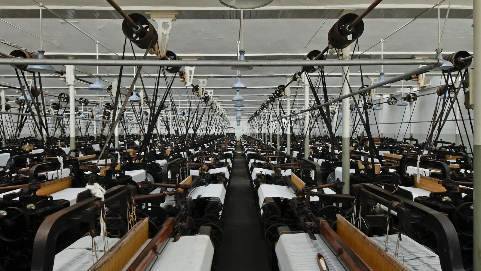 Weaving looms producing fabric in a mill