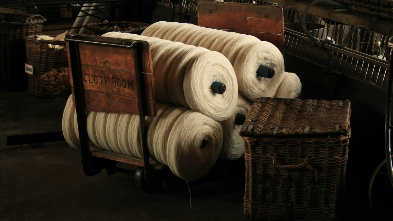 Rolls of yarn on a wooden cart in a textile mill store